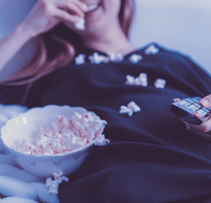 woman wearing black dress shirt eating popcorn