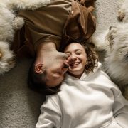 couple lying on the carpet with their dogs