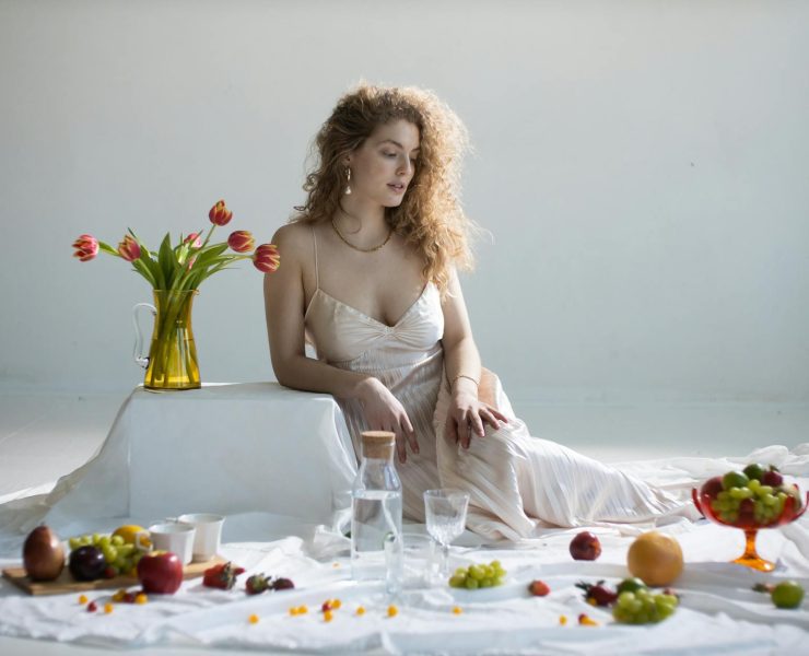elegant young woman near many sweet fruits and tulips
